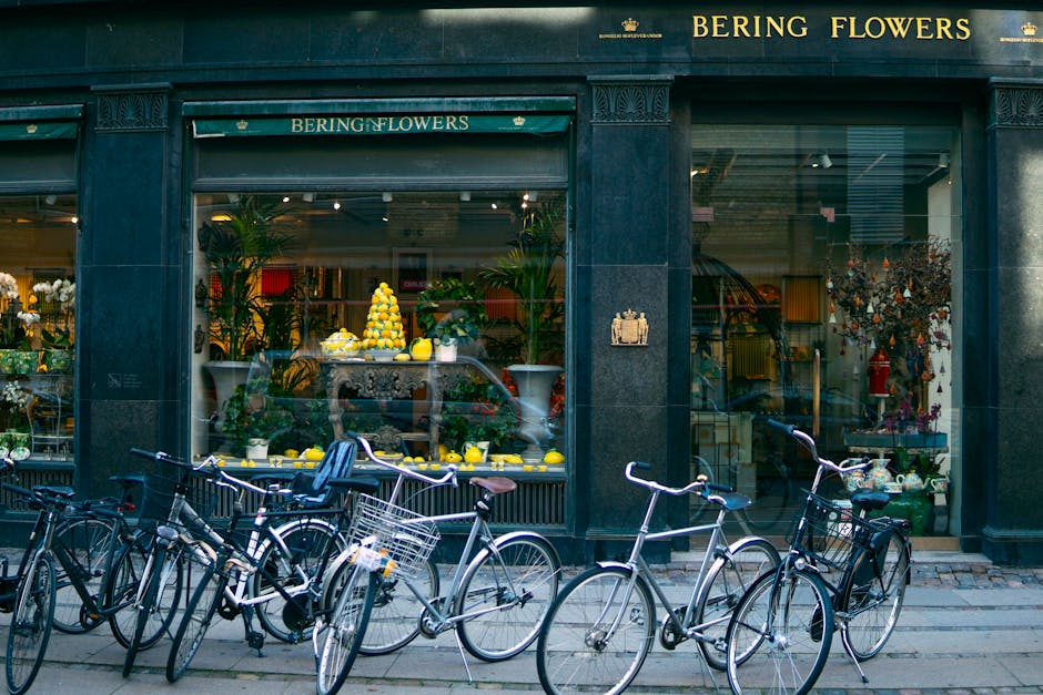The storefront of Bering Flowers on Bath Road Cranford TW5 features large glass windows revealing an elegant floral display inside. The display includes a pyramid-shaped arrangement of yellow lemons a
